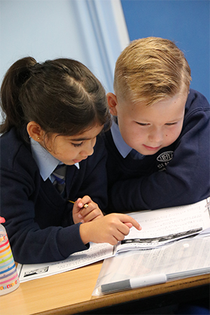 Two young students working together and studying their work books. 